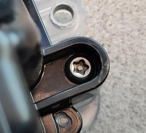 A close up of a pentalobe screw, with a security bit in the middle