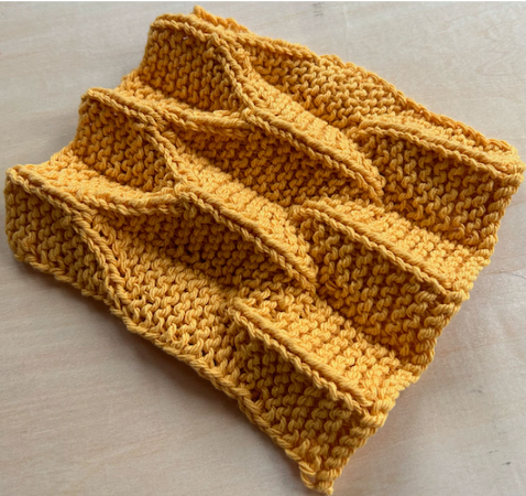 Image from the article linked, a piece of knitted cloth that shows creases and valleys.

"Figure 5.A swatch inspired by the Origami Shawl pattern (Kieper,2019), which uses slip-stitch creases on a garter ground."
