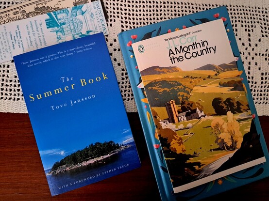 Three books and two bookmarks over a crochet doily