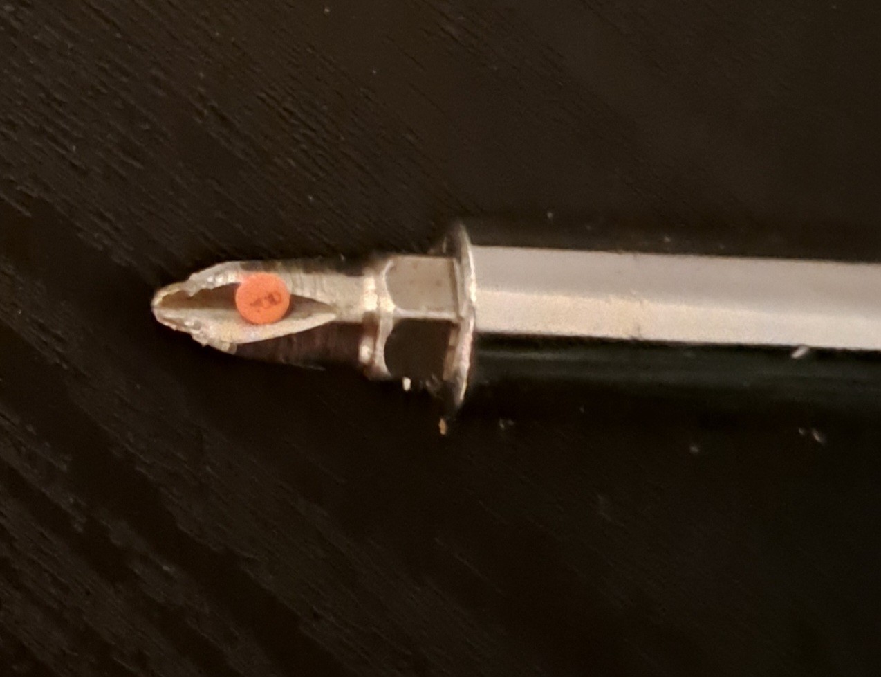 The same sticker, now resting over a screwdriver