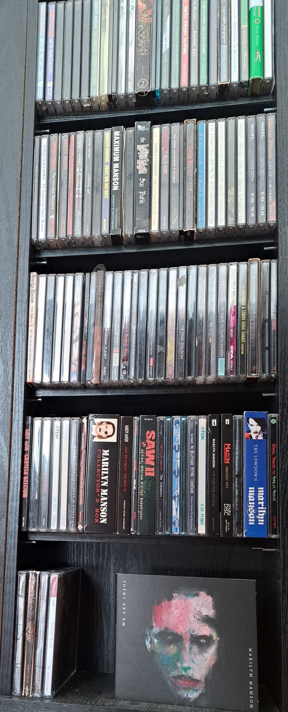 Marilyn Manson's "We Are Chaos" faces the camera at the end of a wall of Marilyn Manson CDs