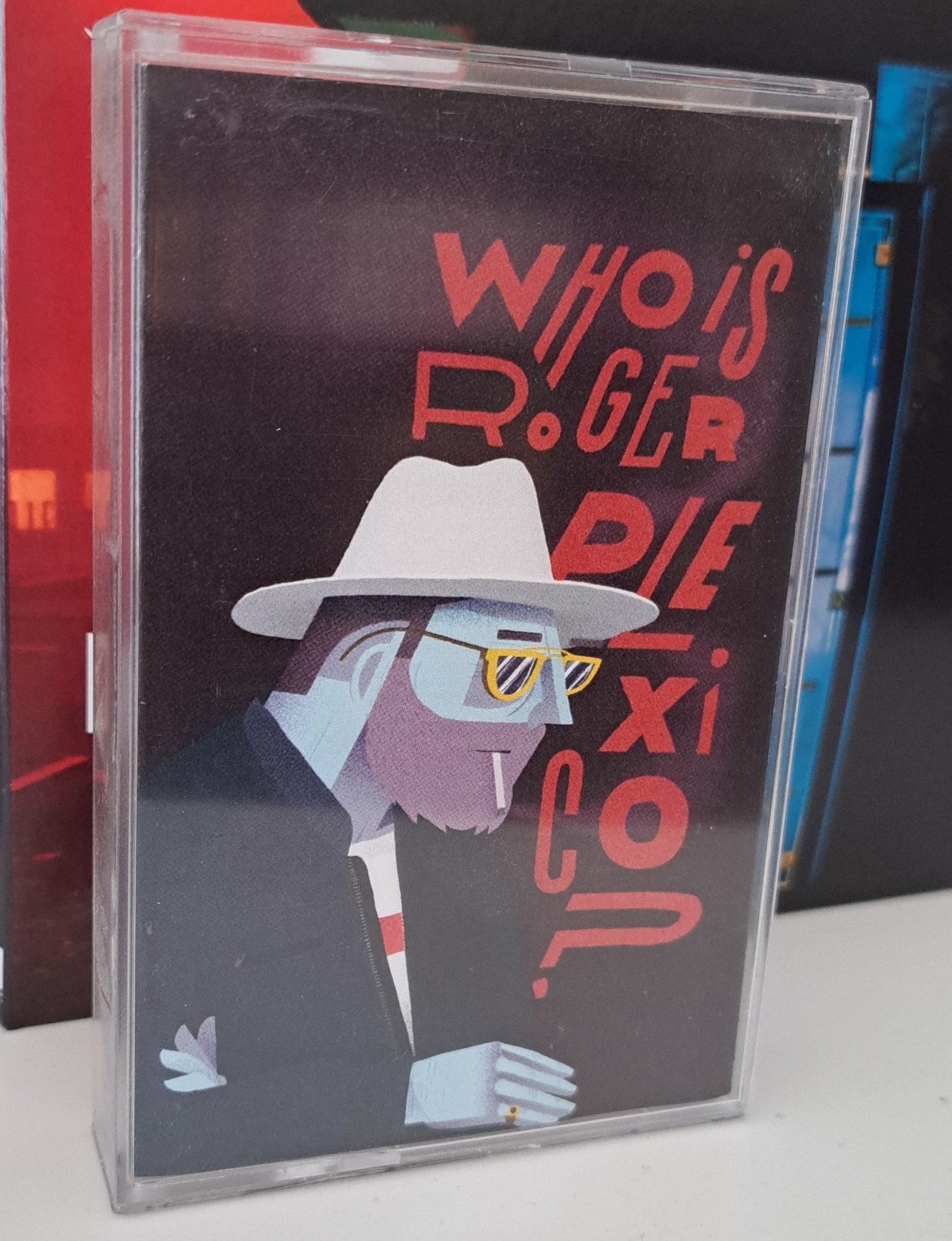 &ldquo;Who Is Roger Plexico?&rdquo; Is the question in the cover of this cassette tape, and also the name of the Roger Plexico EP thus released.  In front of the question, the drawing of Roger Plexico, a guy with an eye mask and sunglasses over it.