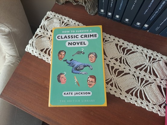 O livro "How to survive a Classic Crime Novel" em cima de uma mesa de madeira