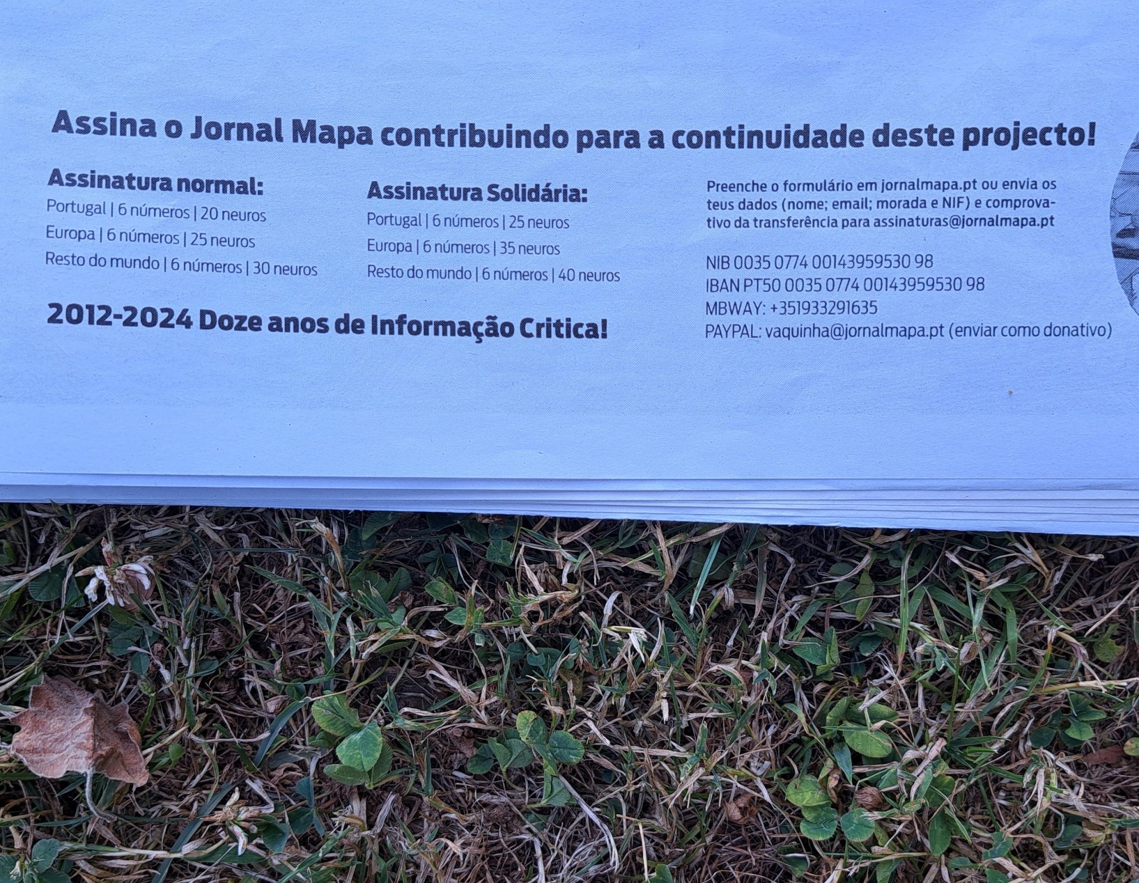 Foto do jornal pousado sobre a vegetação.  No jornal, a informação sobre como assinar, e que pode ser encontrada em https://www.jornalmapa.pt/assinatura-do-jornal/