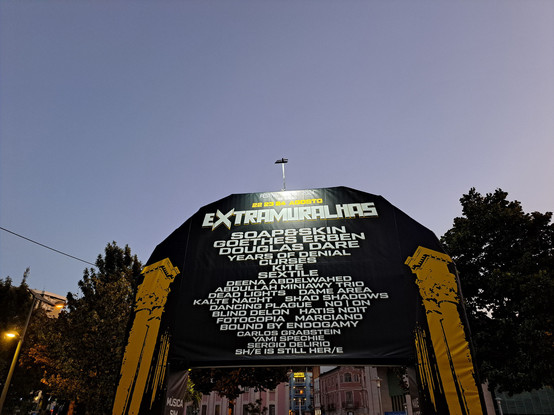 A photo of the free entrance at the gothic music festival extramuralhas that happens every year showing the name of the bands and the sky at dusk
