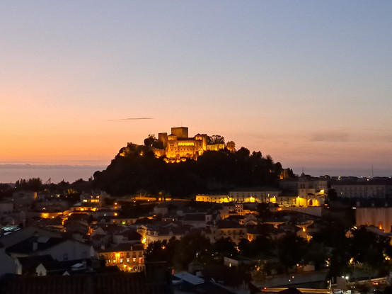 A view to a castle on a hill at sunset