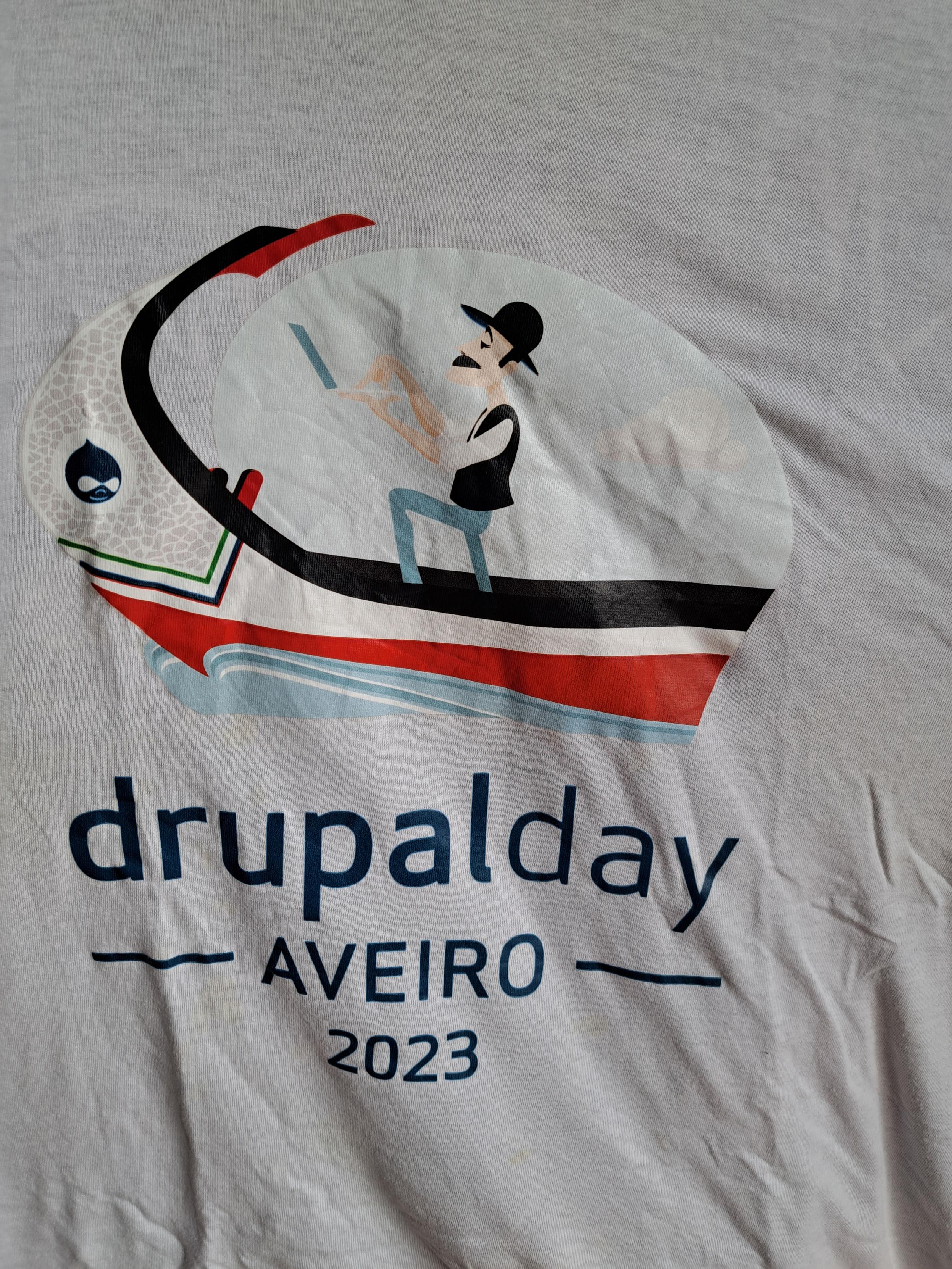 Today is the first day of Drupal Iberia 2026 and to "celebrate" that this week's t-shirt is a "drupalday Aveiro 2023" white t-shirt with a drawing of a moliceiro with Drupal's logo, its driver holding an open laptop.