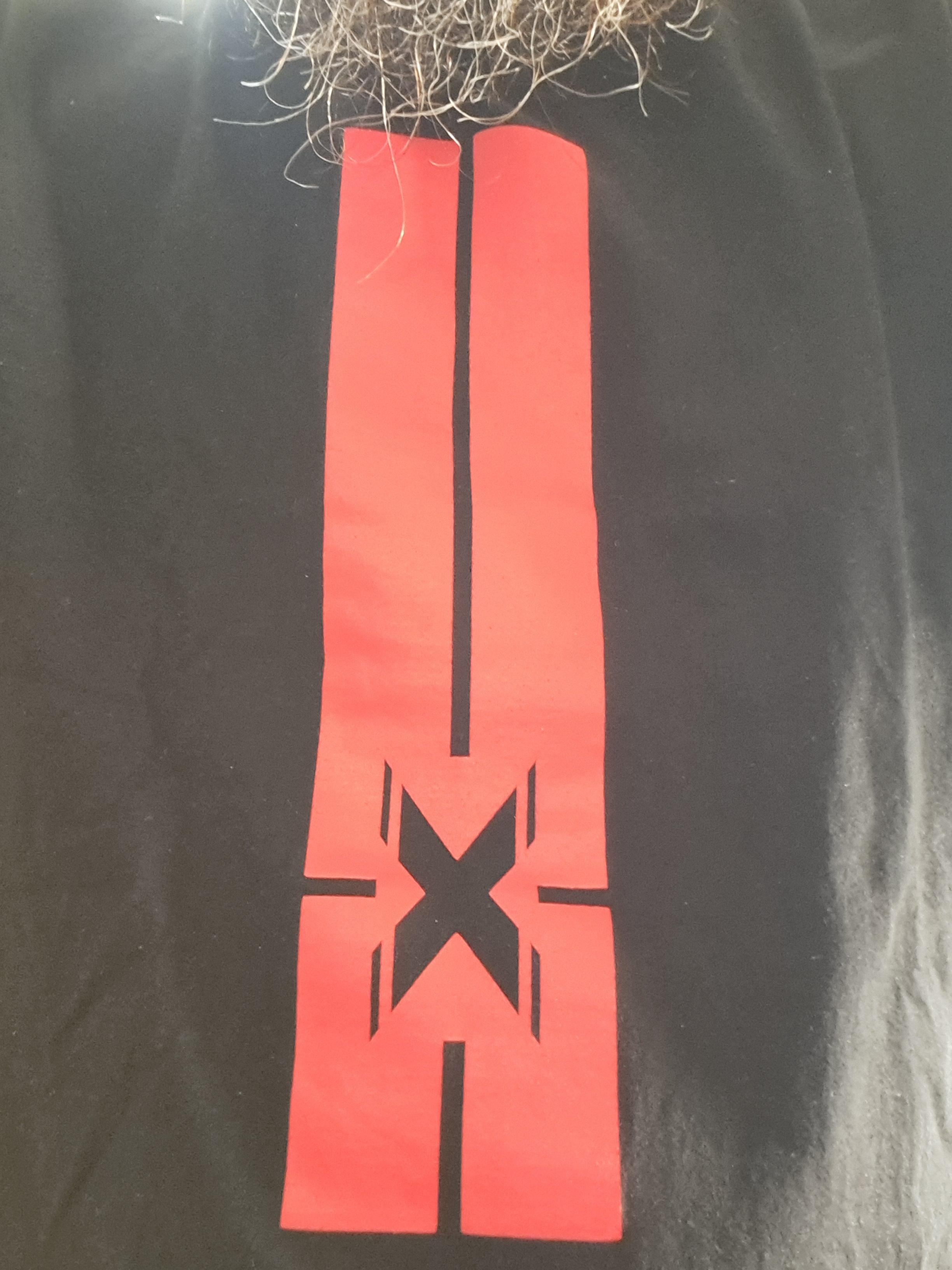 Continuando a saga de t-shirts relacionadas com Leiria, esta é a t-shirt do Extramuralhas 2019, o festival que nasceu Entremuralhas mas depois saiu do castelo e ficou Extramuralhas, e do qual nunca perdi uma edição - 2026 vai ser a primeira vez. Em 2019 ouviram-se bons concertos como o dos Test Dept. e, é claro, o regresso dos Ashram ao festival - e qualquer concerto de Ashram é sempre um grande concerto. A t-shirt é uma faixa vermelha com o X de eXtramuralhas ao centro.