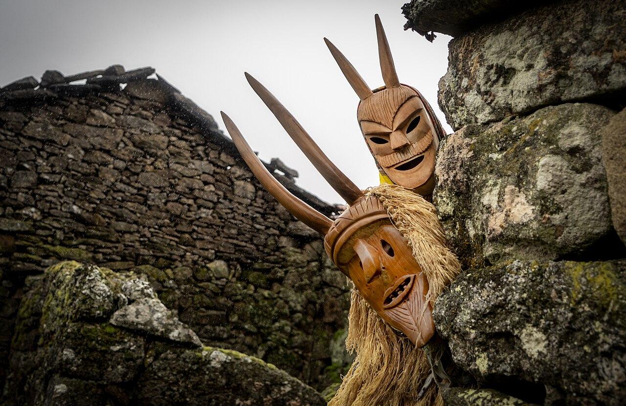 A foto premiada, por António Tedim, mostra dois caretos de Lazarim à espreita na esquina de uma casa de pedra. Mais informação sobre a foto, incluindo a licença, em https://commons.wikimedia.org/wiki/File:Caretos_de_Lazarim_23.jpg
