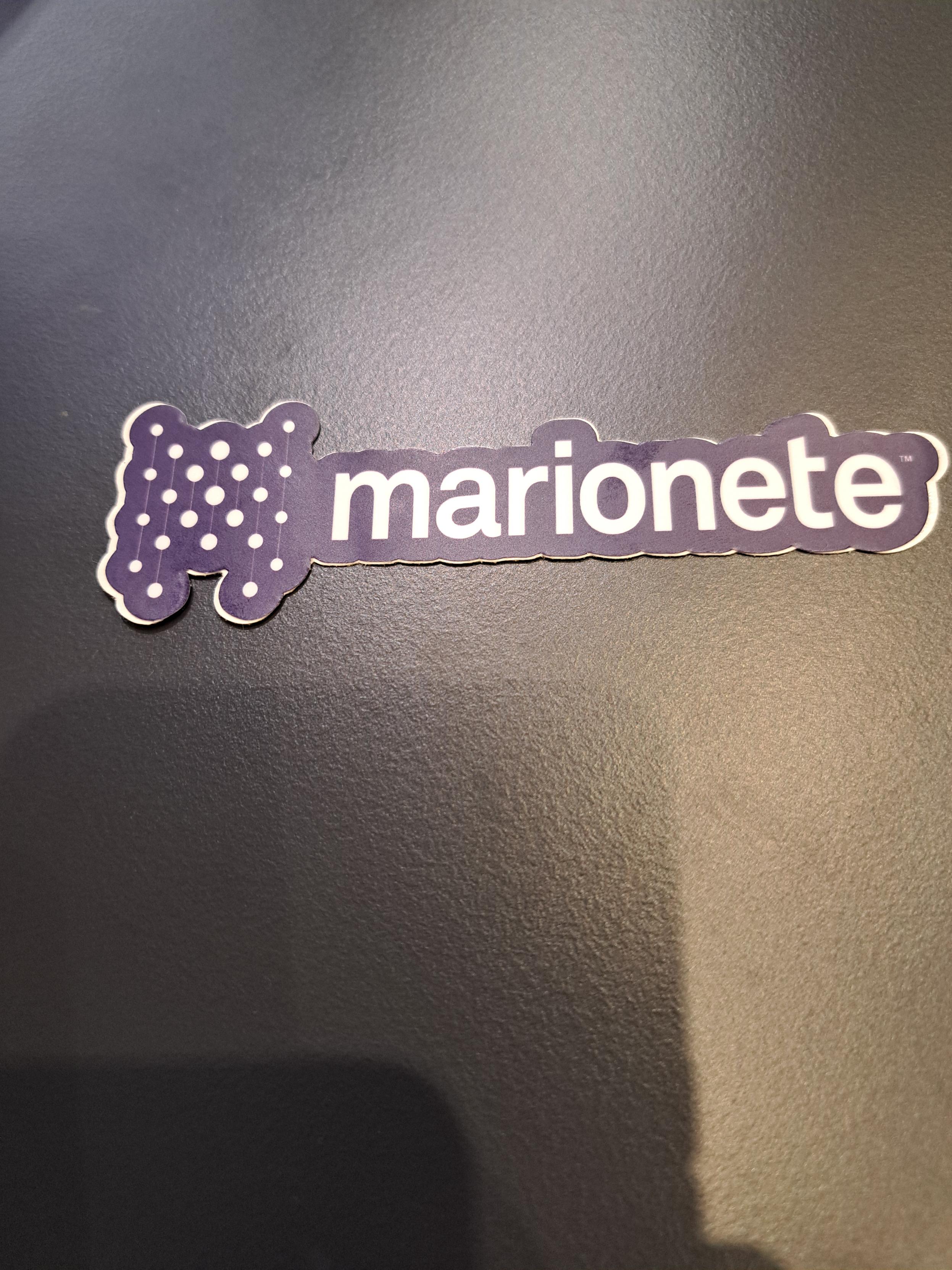 A picture of a sticker with a logo and the text 'marionete', probably of some software with that name